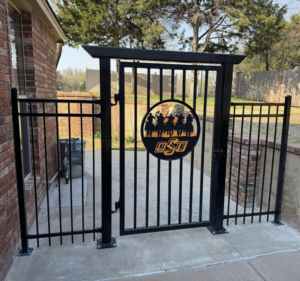 A newly installed black metal fence and gate with an OSU logo by Fence Restorations LLC in Ponca City, OK.