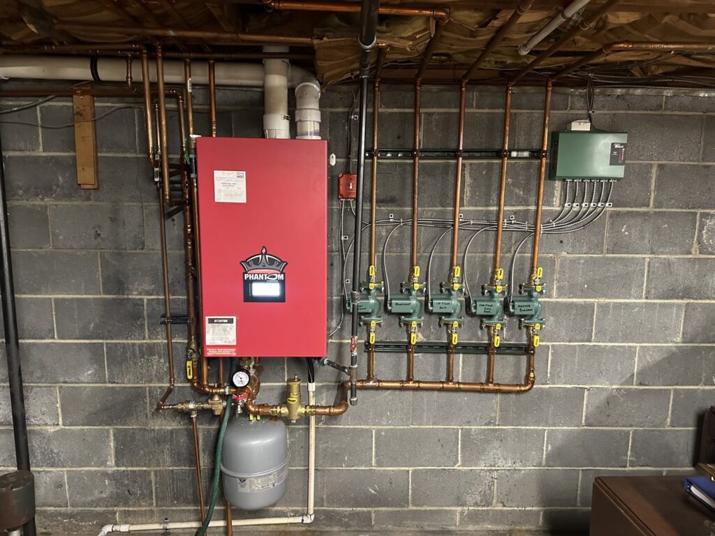 A newly installed red boiler and heating system with copper piping by Accurate Conditioning in Sayreville, NJ.