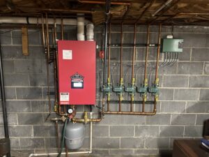 A newly installed red boiler and heating system with copper piping by Accurate Conditioning in Sayreville, NJ.