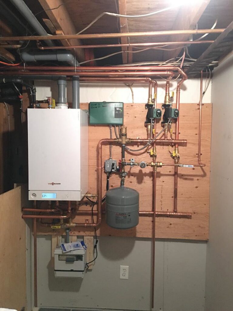 A newly installed wall-mounted boiler and hot water system with copper piping by Nate's Oil Burner Service in New Bedford, MA