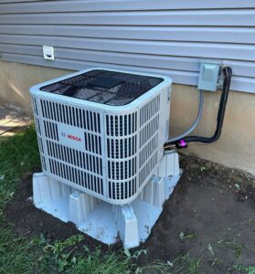 A newly installed Bosch outdoor HVAC unit next to a residential home by APEX Clean Air in South Salt Lake, UT.