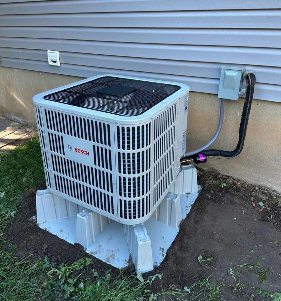 A newly installed Bosch outdoor HVAC unit next to a residential home by APEX Clean Air in South Salt Lake, UT.