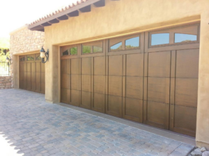Newly installed brown garage doors with windows on a home by SpringMaster Garage Door Service of Chandler, LLC in Chandler, AZ.