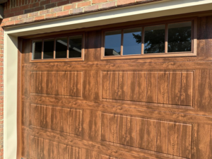 A close-up view of a new brown garage door with windows installed by Mike's Garage Door Repair in Wetumpka, AL.