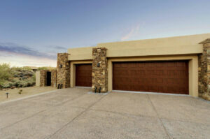 Two new brown panel garage doors installed on a stucco home by Sonoran Garage Doors in Mesa, AZ