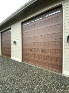 New brown wood-look garage doors with top windows installed by Steadfast Garage Door Services LLC in Federal Way, WA.