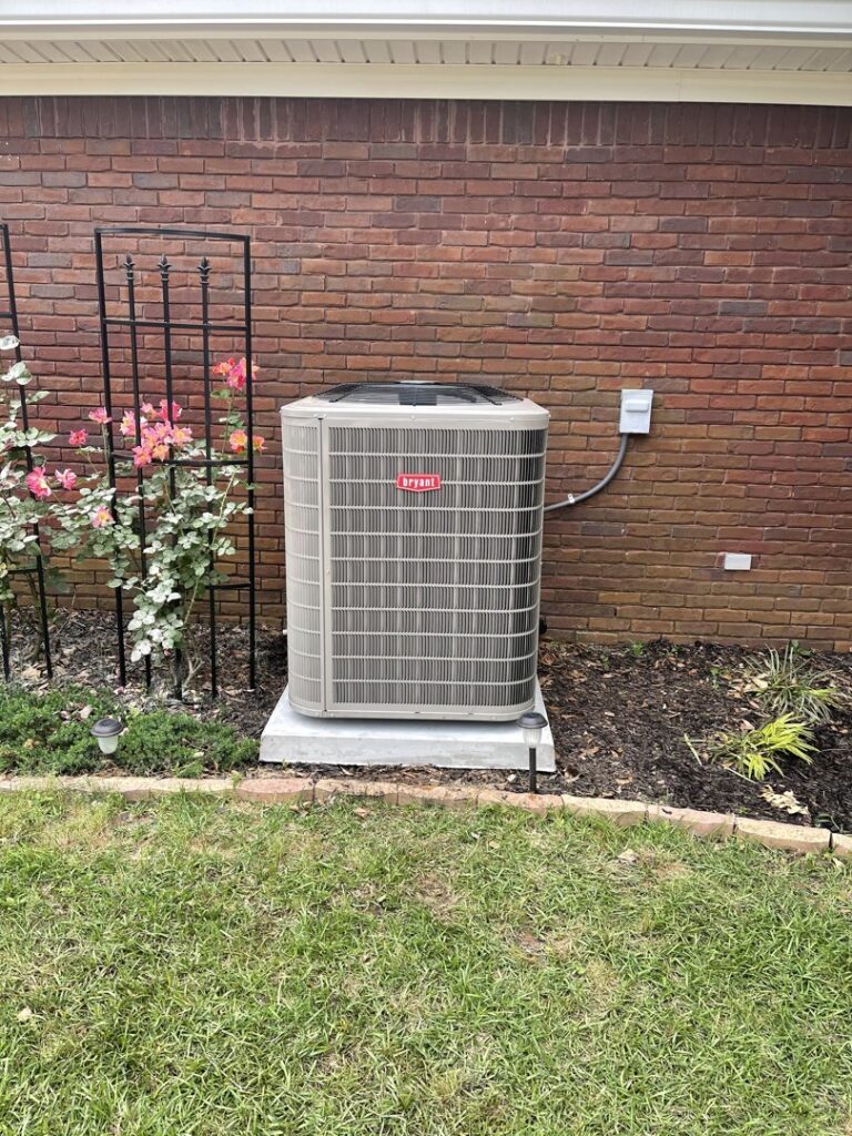 A newly installed Bryant outdoor AC unit next to a brick wall by Frye Air Services in Mobile, AL