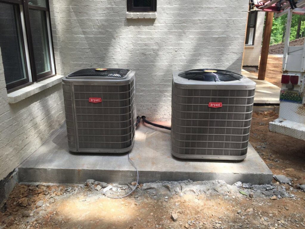 Two newly installed Bryant outdoor air conditioning units next to a home by Douglas Cooling & Heating in Pelham, AL.