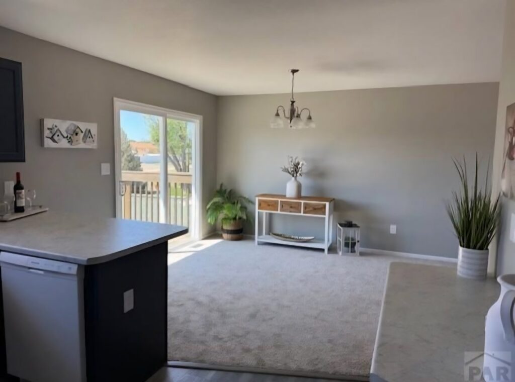 A room with new light brown carpet and adjacent hard flooring installed by Carpet Clearance Warehouse Pueblo, CO.