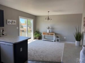 A room with new light brown carpet and adjacent hard flooring installed by Carpet Clearance Warehouse Pueblo, CO.