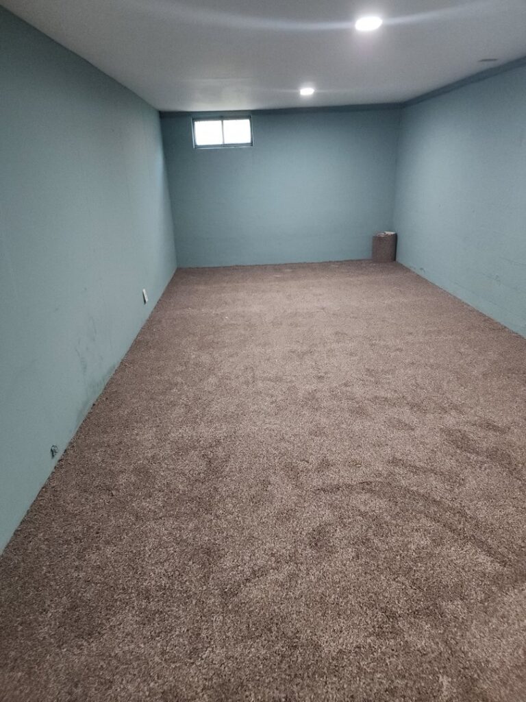 A newly carpeted basement room with brown plush carpet, demonstrating a quality installation by ALL Floorz in Toledo, OH.