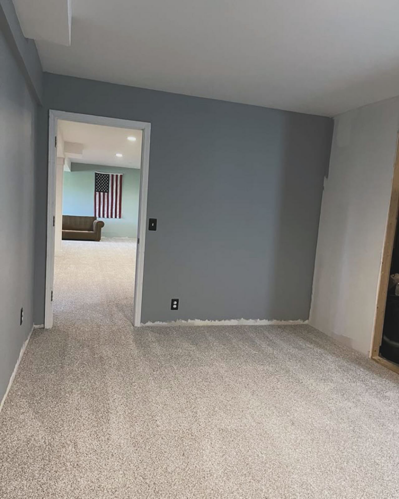 A newly installed light grey carpet in a finished basement room by Rosas Carpet & Flooring in Shorewood, IL.