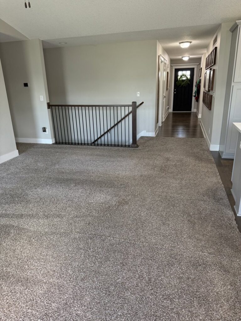 Newly installed gray carpet in a spacious living room by G and L Flooring Plus in Ankeny, IA.