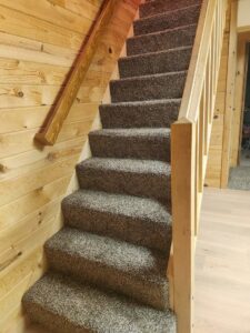 A newly installed grey speckled carpet on a staircase by N-B-R Floors in Fort Collins, CO