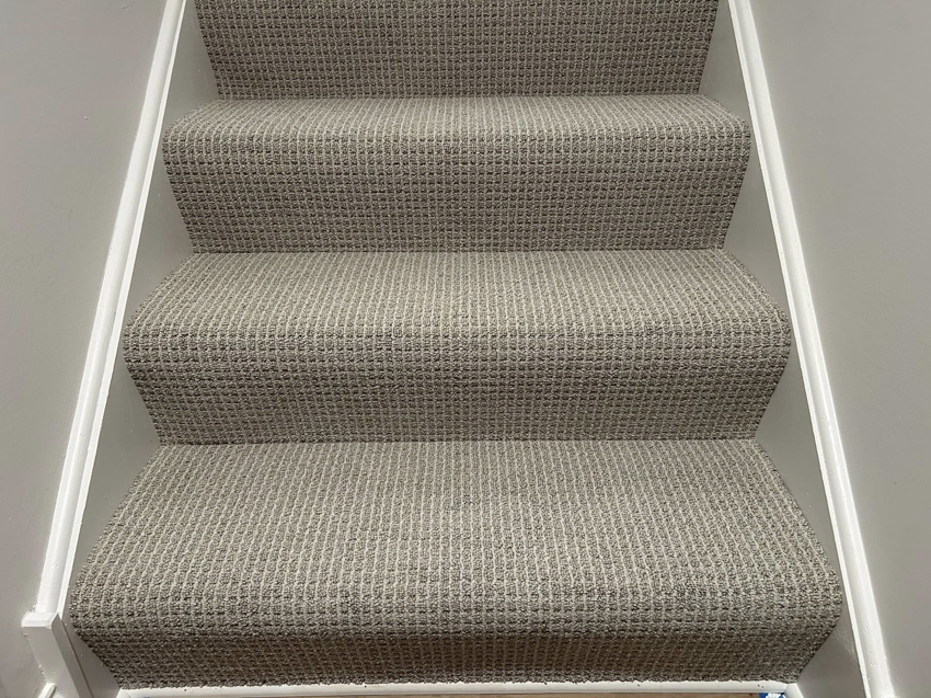Newly installed patterned carpet on a staircase by Creative Carpet Solutions LLC in Houston, TX.