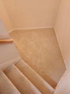 Newly installed light-colored carpet on a stair landing by Zubeck Flooring, a carpet contractor in Blue Springs, MO