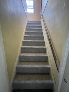 Newly installed gray carpet on a staircase by Flooring World Wide LLC in Plainwell, MI.