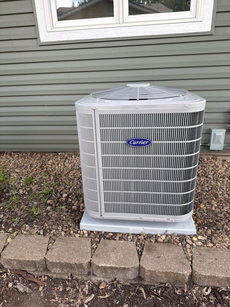 A newly installed Carrier air conditioning unit outside a home by Bloomington Heating & Air in Bloomington, MN.