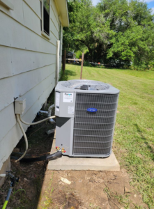 A new Carrier outdoor air conditioning unit installed next to a residential building by ARKLA AIR LLC in Springhill, LA.