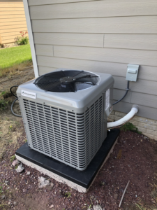 A newly installed Champion outdoor AC unit next to a residential home by Air Care in Sioux Falls, SD.