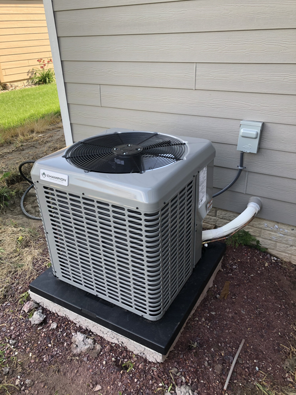 A newly installed Champion outdoor AC unit next to a residential home by Air Care in Sioux Falls, SD.