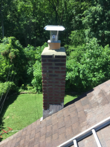 A newly installed chimney cap on a brick chimney, showing a completed job by Charmed Chimney Service in Baltimore, MD.