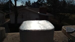 A newly installed metal chimney cap on a residential chimney, completed by Chimney Karma in Fort Collins, CO.