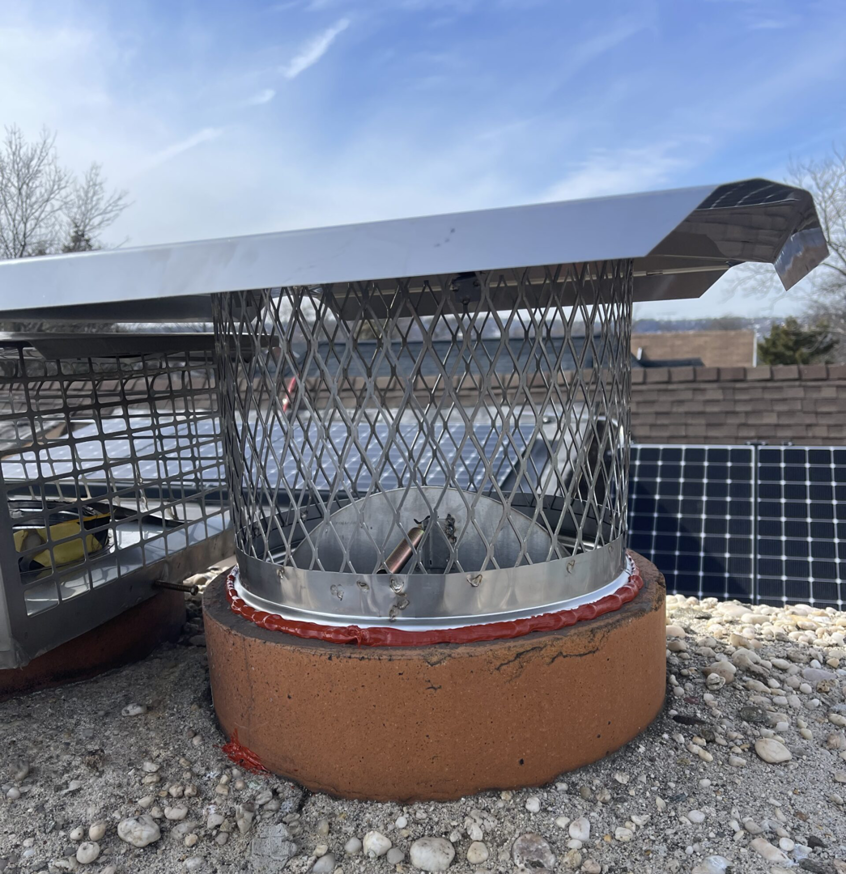 A newly installed chimney cap and liner on a rooftop by Chimney Sweep Service LLC in Brooklyn, NY.