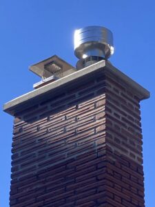 A newly installed metal chimney cap on a brick chimney by Full Service Chimney in Overland Park, KS