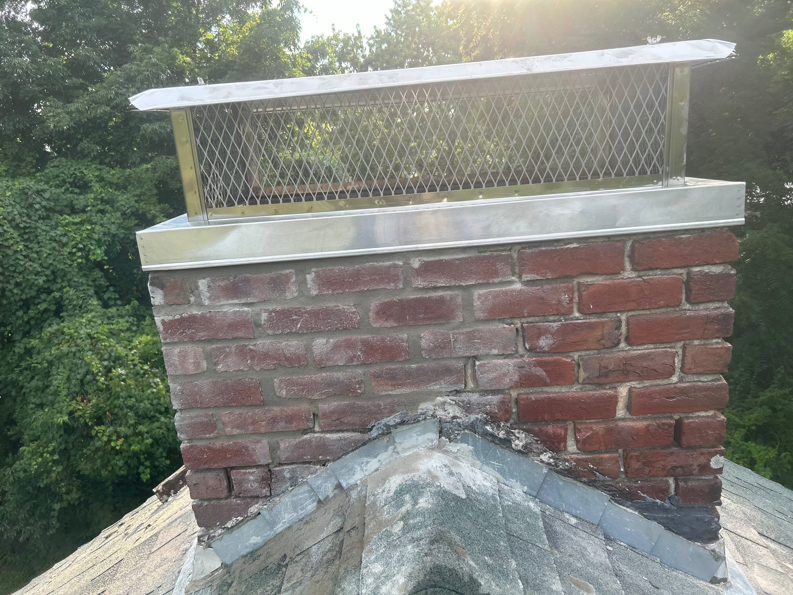 A newly installed metal chimney cap on a brick chimney by The Chimney Guys in Jackson, TN.
