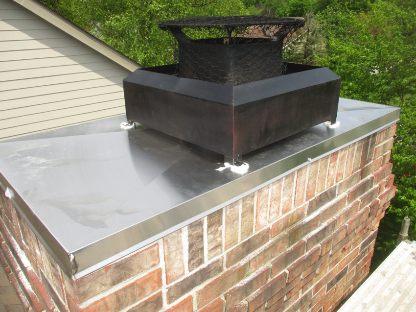 A newly installed metal chimney cap and flashing on a brick chimney by The Mad Hatter in Raleigh, NC