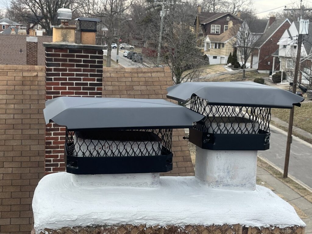 Two newly installed black chimney caps on a residential chimney by Royal Chimney's in Blue Ash, OH.