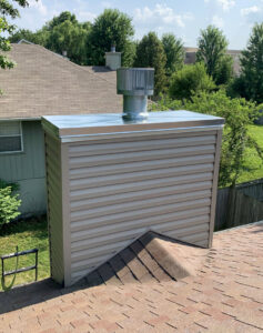 An exterior chimney with new siding and a metal cap installed by Full Service Chimney in Overland Park, KS