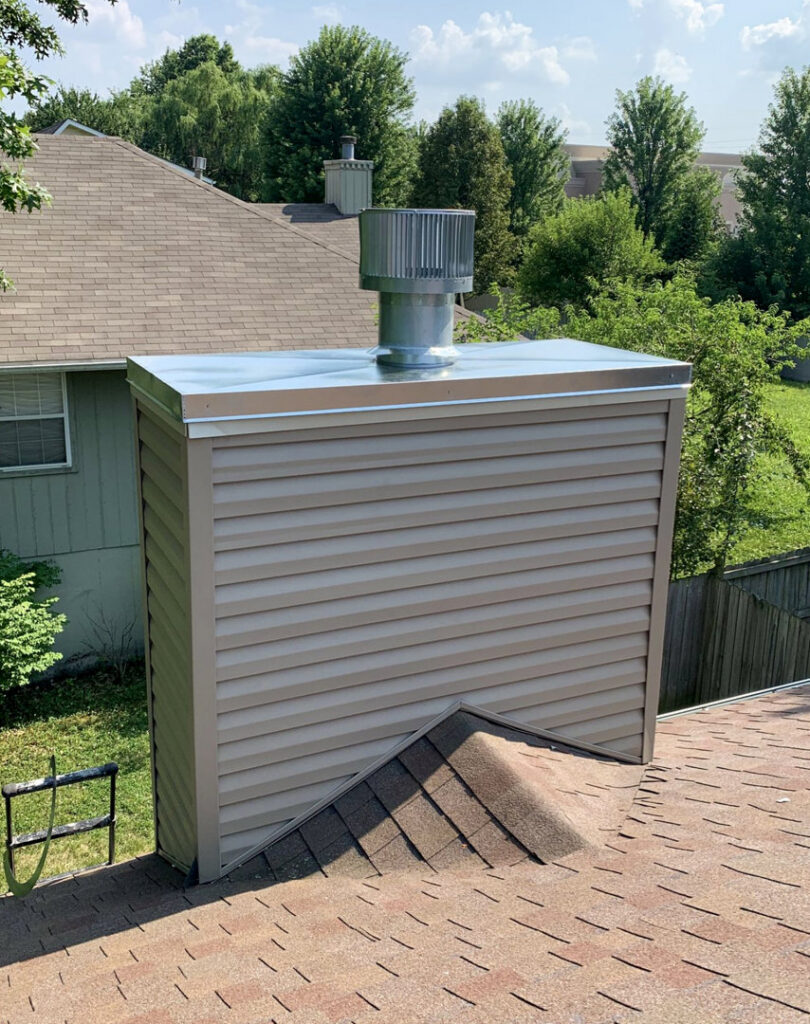 An exterior chimney with new siding and a metal cap installed by Full Service Chimney in Overland Park, KS