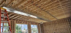 Large metal ductwork being installed in a new construction building with exposed wooden framing by HoxAir Heating & Cooling in Phoenix, AZ