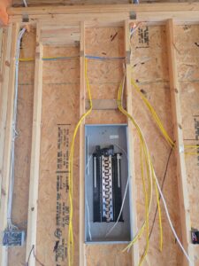 An electrical panel installation during new construction, with wires routed through wall studs by Grounded Electric LLC in Smithfield, VA.