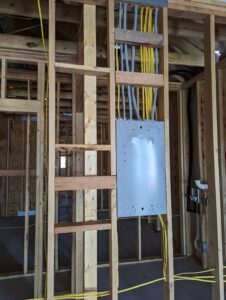 An electrical panel box and wiring installed in a wooden framed wall during new construction by My A Plus Electric SA in San Antonio, TX