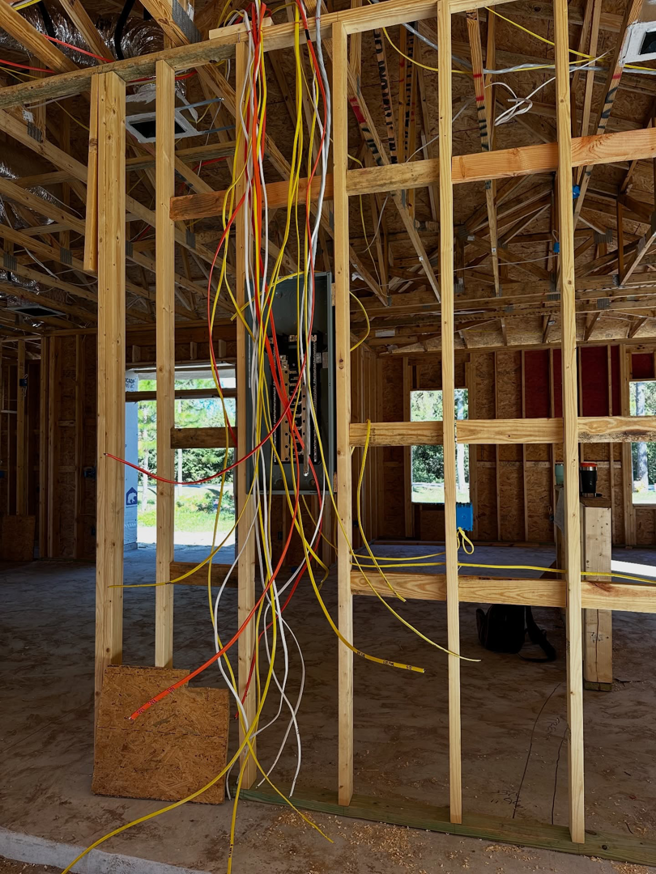New construction electrical rough-in with wires and a breaker panel in a home by Bold City Electric in Jacksonville, FL.