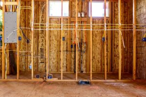 New construction house framing with electrical wiring and junction boxes installed by Phoenix Electric, Inc. in Cape Coral, FL