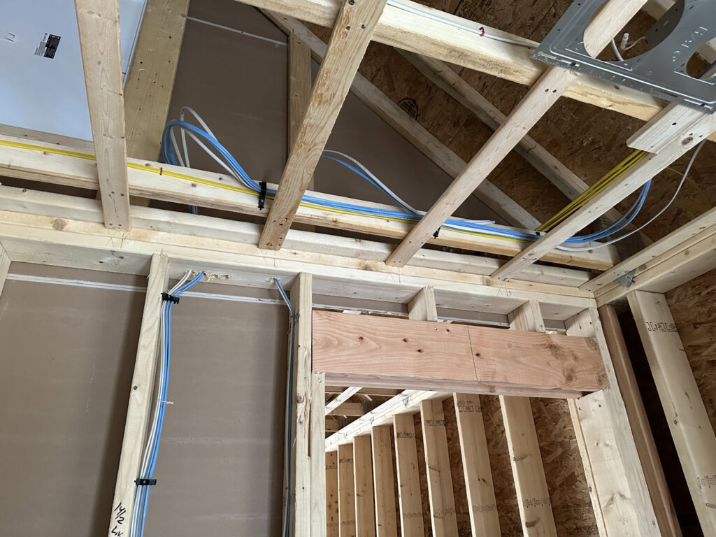 Electrical wiring installed through wooden studs and ceiling joists during new construction by RAD-WIRE ELECTRIC, LLC in Manchester, NH.