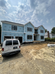 A new construction home with a branded Eriginal Electric LLC van on site for electrical installation in Waterbury, CT.