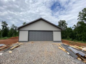A newly installed grey garage door on a new construction building by Foothills Garage Door Service LLC in Louisville, TN.