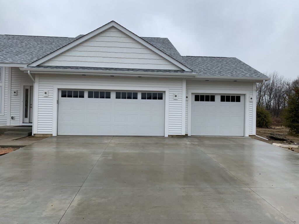 Two new white garage doors installed on a residential new construction project by Superior Overhead Door, LLC in Granger, IN