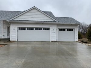 Two new white garage doors installed on a residential new construction project by Superior Overhead Door, LLC in Granger, IN
