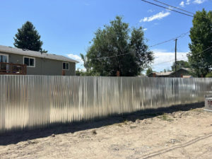 A newly installed corrugated metal fence in a residential backyard by Tomahawk Fencing in Riverton, WY.
