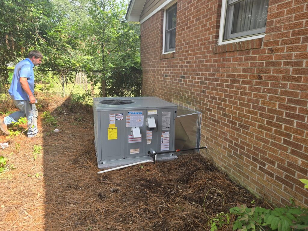 A new Daikin outdoor HVAC unit installed next to a brick house by All American Heating and Air in Warner Robins, GA.