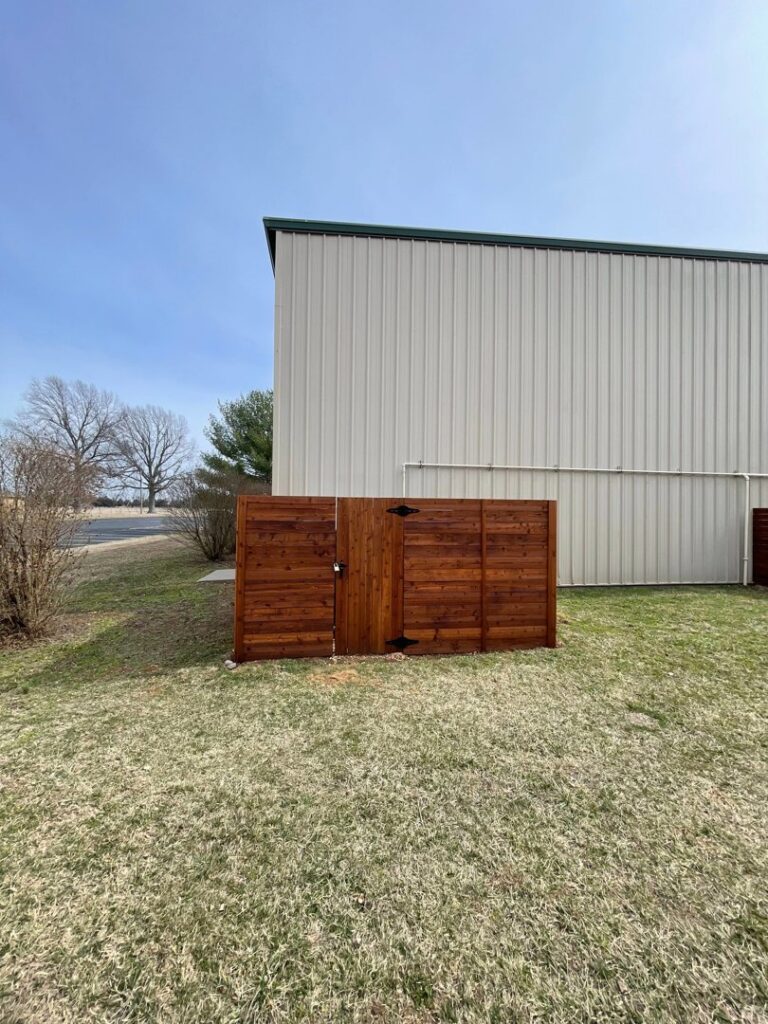 A newly installed dark brown wood privacy fence with a matching gate by Axiom Fence LLC in Springfield, MO.