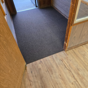 Newly installed dark carpet transitioning from wood-look flooring by LaValle Flooring Inc - Jamestown, ND