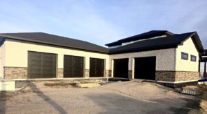 Newly installed dark garage doors on a modern house by Lion Heart Garage Doors in Thornton, CO.