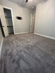 A new dark gray carpet installation in a bedroom by Texas Tuff Floors in Dallas, TX